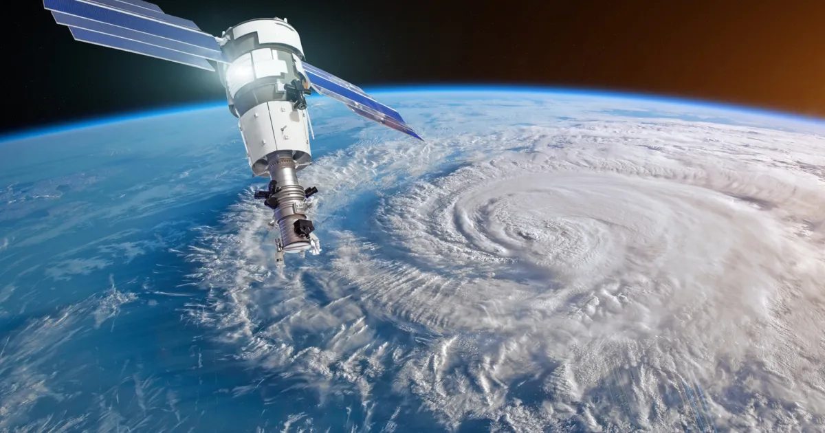 Satellite docked to space station above a massive hurricane seen from space, with Earth’s curved horizon in the background