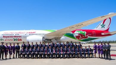 img-0073 | MCG24 | موقع إلكتروني مغربي شامل متجدد على مدار الساعة Royal Air Maroc aircraft on the tarmac with a large group of crew members posing in front under a clear blue sky, tan-red banners visible.