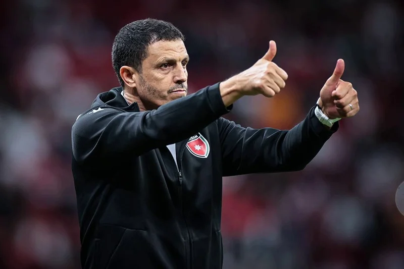 jamal-sellami | MCG24 | موقع إلكتروني مغربي شامل متجدد على مدار الساعة Coach on the sideline giving double thumbs up, wearing a black jacket with a team crest on the chest.