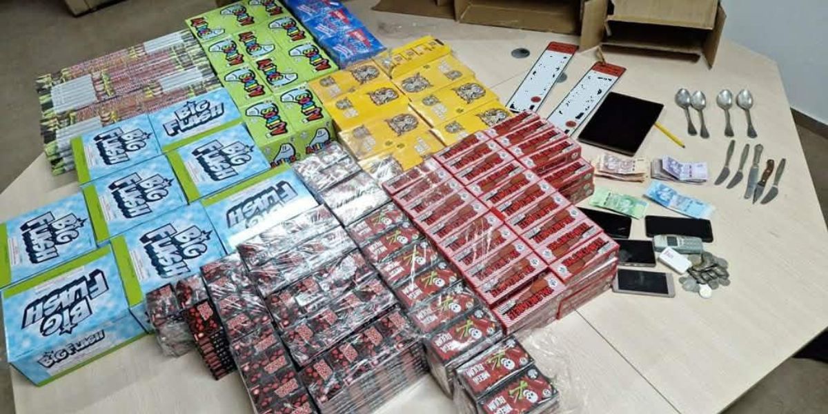 police | MCG24 | موقع إلكتروني مغربي شامل متجدد على مدار الساعة Assorted boxed products arranged in rows on a table, with blue, red, yellow packaging, plus several mobile devices, coins, and a few spoons and knives visible on the right.