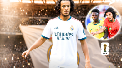 ssssssszazs | MCG24 | موقع إلكتروني مغربي شامل متجدد على مدار الساعة Real Madrid footballer in white kit walking toward the camera on a stadium pitch, Emirates Fly Better sponsor visible; circular inset shows two other players and a red-jersey teammate with a FIFA World Cup trophy icon.