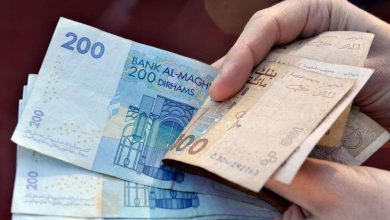 أموال-1 | MCG24 | موقع إلكتروني مغربي شامل متجدد على مدار الساعة Hand holding a fan of Moroccan dirham banknotes (200 and 100).