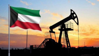 Kuwait flag waving beside an oil pumpjack at sunset, silhouetted foregrounds.