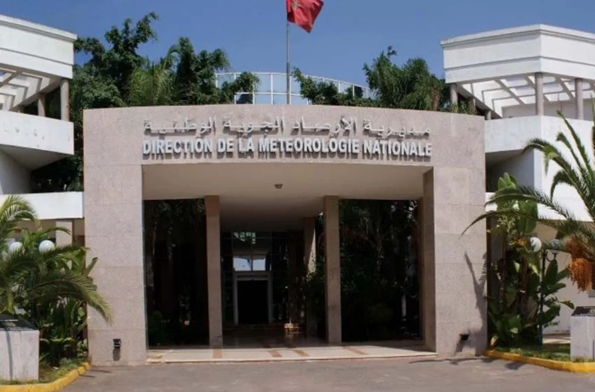 المديرية-العامة-للأرصاد-الجوية- | MCG24 | موقع إلكتروني مغربي شامل متجدد على مدار الساعة Entrance to the National Meteorology Directorate building with palm trees and a red flag atop the structure.