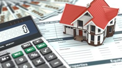 بيع-شقة | MCG24 | موقع إلكتروني مغربي شامل متجدد على مدار الساعة Calculator and a small house model on mortgage documents, illustrating home financing planning