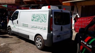 جثة٨ | MCG24 | موقع إلكتروني مغربي شامل متجدد على مدار الساعة White van with green Arabic lettering parked on a busy street, likely a humanitarian aid vehicle.